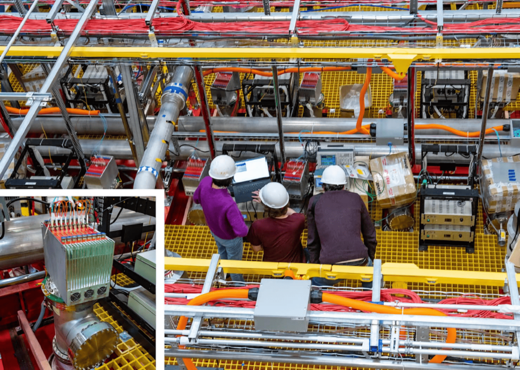 Workers stand on the platform above the ICARUS detector while installing some final components. &copy; Fermi National Accelerator Laboratory.